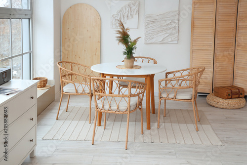 Foto Interior of light room with dining table and 3D paintings