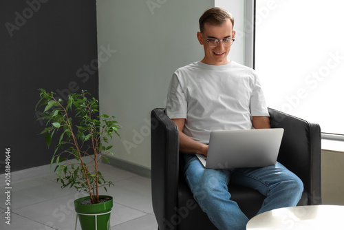 Young man with laptop messa...