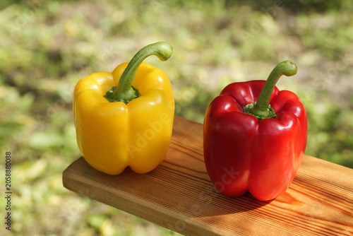 Foto Yellow and red bell peppers on wood board