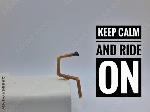A burnt matchstick bent into a stick figure shape sits calmly on the edge of a white surface.