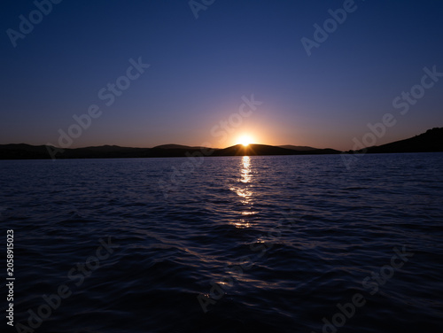 Brilliant golden sun trail reflection dancing on the rippling surface of the sea