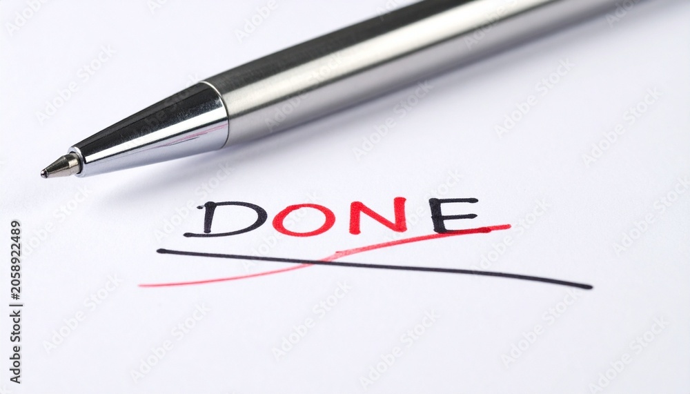 Fototapeta premium Silver pen on paper marking completion with bold “DONE”
