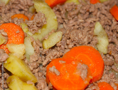 Minced beef stew with diced carrots and potatoes. Homemade comfort food cooked with vegetables. meal served for lunch. Ground beef with carrots and potatoes with selective focus.