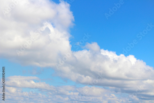 Fluffy white clouds in a bright blue sky. Clear atmosphere with cloud formations. Sky with selective focus. Blue sky with clouds.