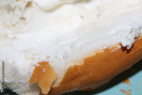 Slice of bread with creamy cheese spread. Delicious breakfast bread with cream cheese. Close up of bread slice with spread. Bread with selective focus. Piece of bread with cream cheese.