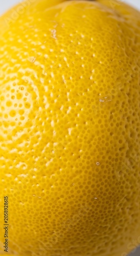 Close-up view of a vibrant yellow lemon skin texture, detailed and fresh.