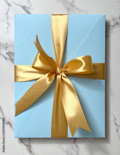 Light blue envelope with a golden ribbon tied into a bow