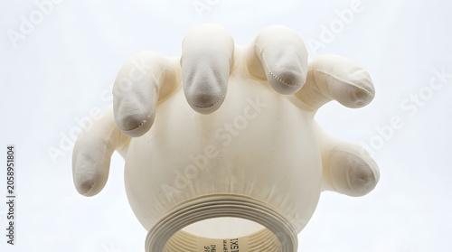 Close-up of a sterile medical glove, the fingertips poised as if to grasp, embodying a sense of caution and care in healthcare settings.