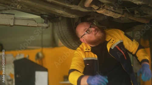 Caucasian male mechanic with glasses and a beard works alongside a female technician, reviewing a digital tablet and giving a thumbs-up. This high-energy commercial imagery represents gender diversity