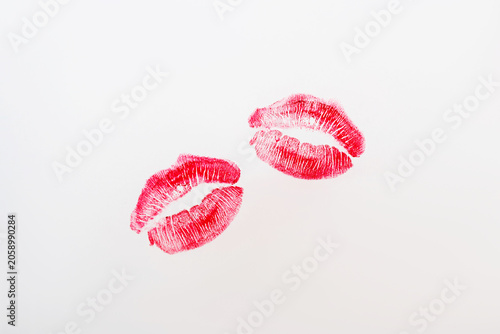 Two red lipstick kiss prints on a white background. Minimal contemporary art composition with sensual beauty concept and copy space