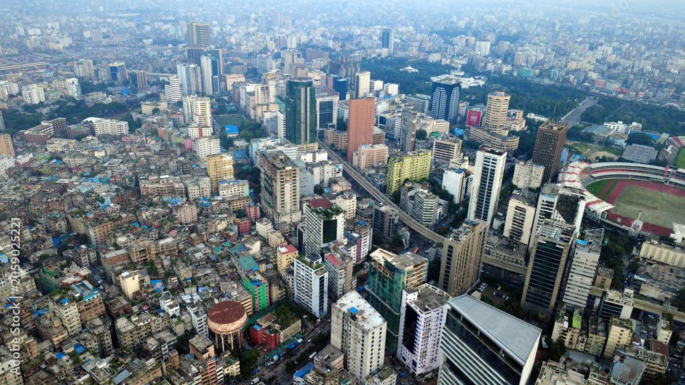 Fototapeta premium This impressive aerial view of Dhaka highlights the modern infrastructure and dynamic urban landscape of Bangladesh’s capital. The image showcases a network of elevated flyovers, highways, rail lines.