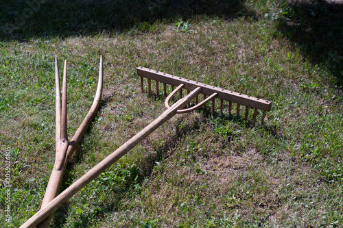 wooden rake and pitchfork on field 