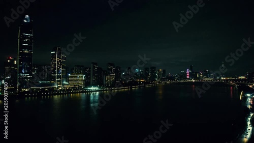 Illuminated city skyline at night over water