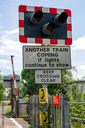 Obraz na płótnie Warning sign and red signal lights at a railway level crossing in Northway, Tewk