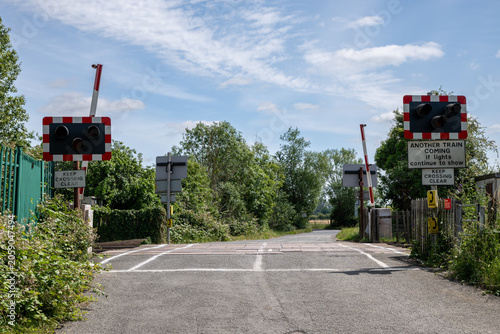 Foto Railway level crossing with road, signals and barriers in Northway, Tewkesbury,
