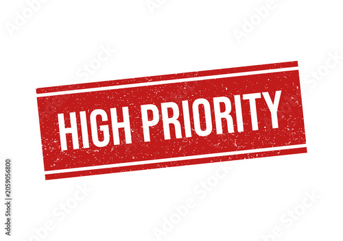 Red grunge rubber stamp with the text high priority on flat surface