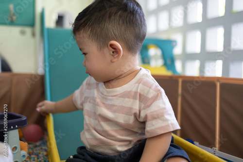 
Child plays with colorful plastic balls on yellow slide. Hands hold small tool, feet touch soft beads. Joyful, curious child explores playful, sensory environment. Perfect for preschool, therapy

