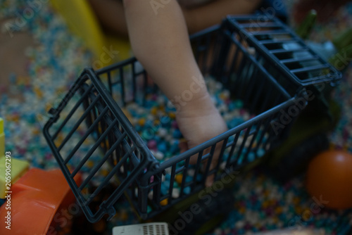 
Child plays with colorful plastic balls on yellow slide. Hands hold small tool, feet touch soft beads. Joyful, curious child explores playful, sensory environment. Perfect for preschool, therapy
