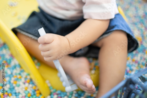 
Child plays with colorful plastic balls on yellow slide. Hands hold small tool, feet touch soft beads. Joyful, curious child explores playful, sensory environment. Perfect for preschool, therapy
