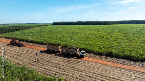Aerial view of agricultural storage facility and vibrant green fields with dirt road