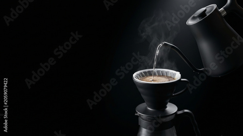 Pouring hot water over coffee in a drip brewer