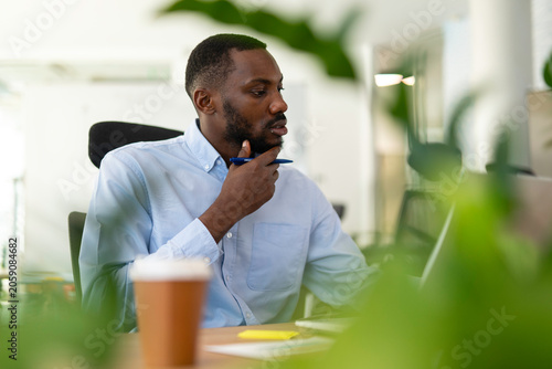 Foto Black entrepreneur concentrating on work in modern office