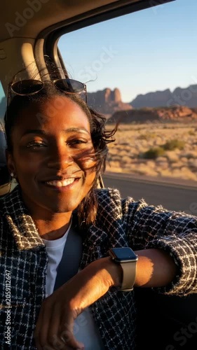 Smiling woman leaning out of a car window during a desert road trip at golden hour. candid travel portrait capturing joy and sunset mood.