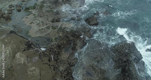 Aerial view of waves crashing against rocky coastline The Concept of raw power