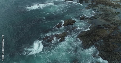 Powerful marine landscape capturing the raw energy of waves impacting against a jagged stone coast
