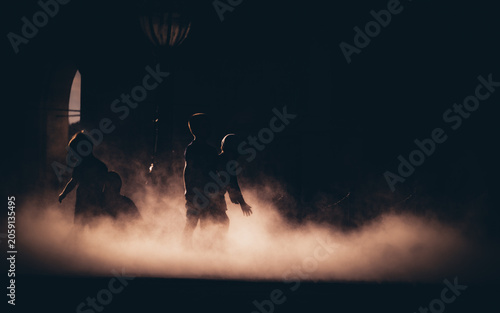 Silhouette of children playing in the thick fog at twilight