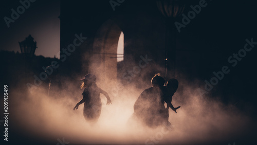 Silhouette of children playing in the thick fog at twilight