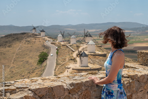 Photos Woman in blue floral dress overlooking the famous windmills of Consuegra in Castilla-La Mancha, Spain