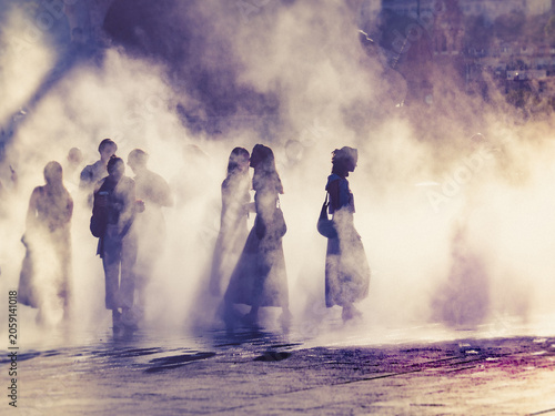 Children and people playing in a mystical fog at sunset