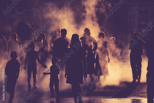 Children and people playing in a mystical fog at sunset