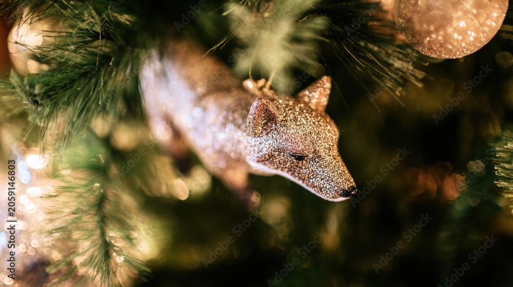 Obraz premium Decorative fox ornament hanging on a Christmas tree with lights and sparkles