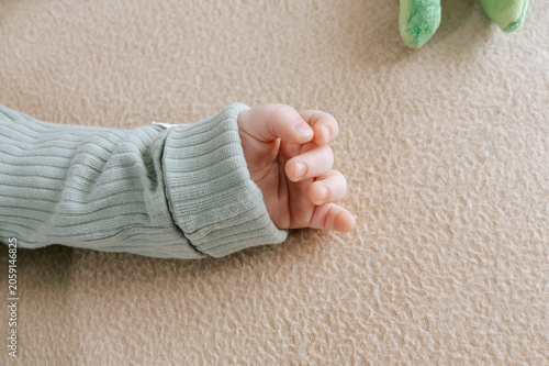 Little hand of a cute baby with selective focus. Adorable newborn boy fingers close up