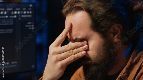 Schilderij op canvas Disappointed computer scientist puzzled after being unable to remove all bugs while coding on workstation desktop