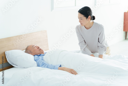 Bild auf Leinwand 寝たきりの高齢者を看病する女性