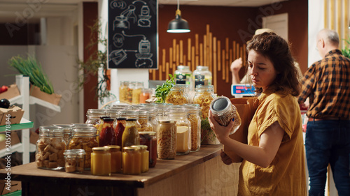 Bilde på lerret Customers shopping in eco friendly zero waste supermarket run by zealous storekeeper, clients purchasing freshly harvested food from environmentally friendly local neighborhood store