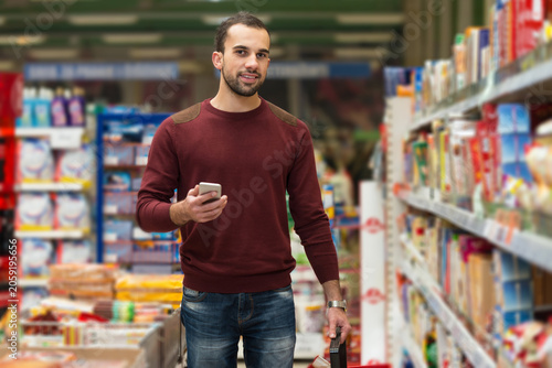 Canvastavla Man Looking At Mobile Phone In Shopping Centre