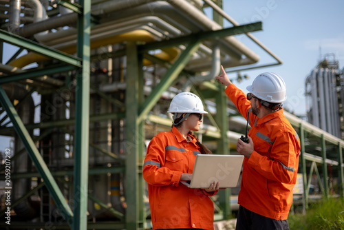 Schilderij op canvas Engineers discussing industrial plant structure showing teamwork and technology