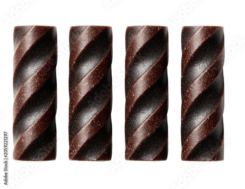 Four dark, cylindrical chocolates with swirling pattern against black