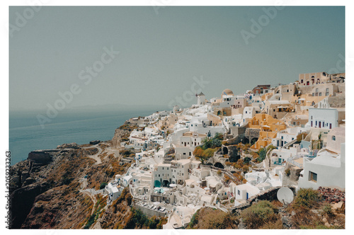 фотографія Sunlit Oia village clinging to the Santorini cliffside