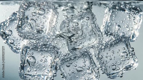 Close-up of clear ice cubes submerged in fizzy carbonated water