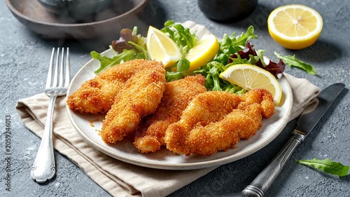 Crispy breaded schnitzel with lemon and fresh salad