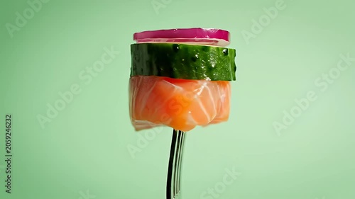 Fresh salmon and cucumber bite on a fork.