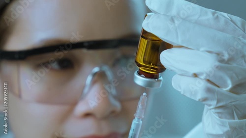 Female Scientist Examining Pharmaceutical Vial During Laboratory Quality Inspection. Pharmaceutical quality control, laboratory inspection, medical research, healthcare innovation