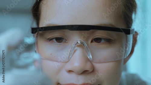 Focused Medical Researcher Analyzing Laboratory Sample Through Safety Goggles