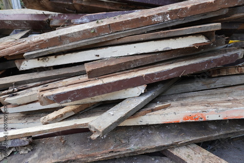 фотографія Pile of weathered and discarded wooden planks with peeling paint and nails