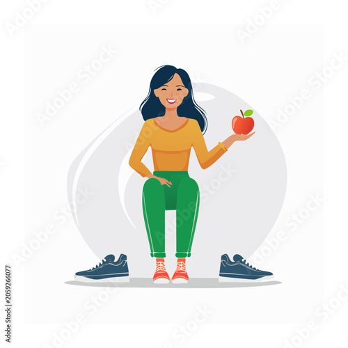 Smiling woman holding an apple in casual outfit